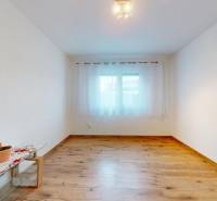 MALÉ LEVÁRE-Predaj  3i modernej novostavby RD s tep. čerpadlom + garáž - Izba s podlahou s dreveným dekorom, bielymi stenami a oknom v rodinnom dome.