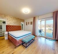 MALÉ LEVÁRE-Predaj  3i modernej novostavby RD s tep. čerpadlom + garáž - Spálňa v rodinnom dome s posteľou, šatníkom a veľkými oknami na terasu.