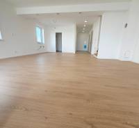 4 izbový RD-128 m2 S TEP. ČERPADLOM, POZEMOK 405m2 - Priestranná izba v rodinnom dome s podlahou s dreveným dekorom a bielymi stenami.