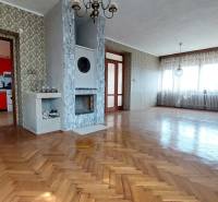PREDAJ - RODINNÝ DOM - ZLATÉ MORAVCE - Obývacia izba v rodinnom dome s krbom a podlahou s dreveným dekorom.