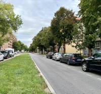 PRENÁJOM 1 izbový byt, 40 M2, Bratislava, Ružinov, Košická ulica, NIVY - Pohľad na zelený pás a cestu v Bratislave - Ružinove s autami a stromami.
