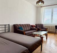 PRENÁJOM 1 izbový byt, 40 M2, Bratislava, Ružinov, Košická ulica, NIVY - Izba s podlahou s dreveným dekorom, posteľou, gaučom, stolíkom a písacím stolom.
