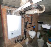 RD so záhradou, pivnicou garážou na Myjave.  - Plynový kotol v pivnici rodinného domu s potrubím a zásobníkom vody na stene.