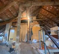 RD so záhradou, pivnicou garážou na Myjave.  - Podkrovie rodinného domu s drevenými trámami, šikmou strechou a uskladnenými vecami.