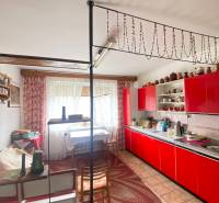 RD so záhradou, pivnicou garážou na Myjave.  - Červená kuchynská linka v rodinnom dome s dekoratívnym závesom a bodkovaným kobercom.