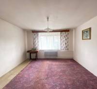 RD so záhradou, pivnicou garážou na Myjave.  - Izba v rodinnom dome s fialovým kobercom, kvetinovými závesmi a lustrom.