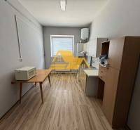 Prenajmem garsónku v Nesvadoch - Jednoduché zariadenie garsónky s kuchynským kútom a podlahou s dreveným dekorom.