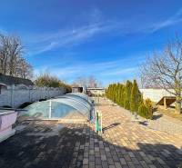 2-Generačný 9izb. RD s bazénom a veľkým pozemkom, Dvorníky - Záhrada s dlažbou a krytým bazénom v rodinnom dome v Dvorníkoch.