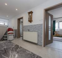 2-Generačný 9izb. RD s bazénom a veľkým pozemkom, Dvorníky - Chodba v rodinnom dome s hodinami na stene a schodiskovým výťahom.