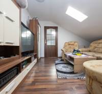 2-Generačný 9izb. RD s bazénom a veľkým pozemkom, Dvorníky - Obývacia izba s pohovkou, televízorom a podlahou s dreveným dekorom v rodinnom dome.