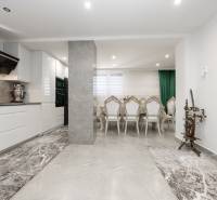 2-Generačný 9izb. RD s bazénom a veľkým pozemkom, Dvorníky - Kuchyňa a jedáleň so stoličkami v Rodinnom dome; kamenná podlaha a tradičný kolovrat.