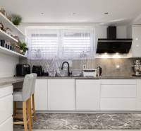 2-Generačný 9izb. RD s bazénom a veľkým pozemkom, Dvorníky - Kuchyňa v rodinnom dome s bielym nábytkom, dekoratívnymi policami a štýlovými spotrebičmi.