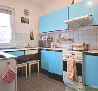 Veľkorysý 10-árový pozemok, slnečná nehnuteľnosť, priestranné bývanie  - Kuchyňa v rodinnom dome s modrými skrinkami a kachličkovou stenou.