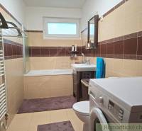 Veľkorysý 10-árový pozemok, slnečná nehnuteľnosť, priestranné bývanie  - Kúpeľňa v rodinnom dome s vaňou, práčkou a hnedo-béžovým obkladom.