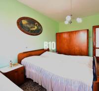 5 izbový  rodinný dom vo Varíne - Spálňa v rodinnom dome s masívnym dreveným nábytkom a dekoratívnym obrazom na stene.