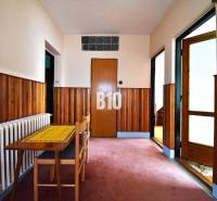 5 izbový  rodinný dom vo Varíne - Chodba v rodinnom dome s dreveným obkladom, stolom a stoličkou.