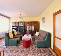 5 izbový  rodinný dom vo Varíne - Obývačka v rodinnom dome s pohovkami, kreslami, vitrínou a kobercom.