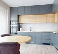 Predaj, 3-izbový byt v Slnečniciach, Bratislava - Kuchyňa v 3-izbovom byte s dreveným dekorom a veľkými oknami.