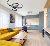 Predaj, 3-izbový byt v Slnečniciach, Bratislava - Obývačka v 3-izbovom byte s podlahou s dreveným dekorom a žltou sedačkou.