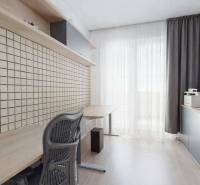 Predaj, 3-izbový byt v Slnečniciach, Bratislava - Pracovňa v 3-izbovom byte s veľkým stolom, úložným priestorom a podlahou s dreveným dekorom.