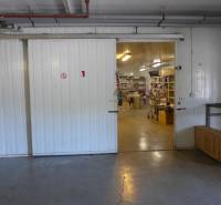 Sklad na prenájom o ploche 95 m2 + kancelária - Otvorená hala so skladovaným materiálom, regálmi a priemyselnými dverami, Sklady a haly.