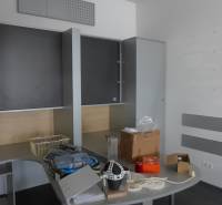 Obchodný priestor na prenájom pri ceste o ploche  372 m2  - Kancelária s úložnými skrinkami a stolom, na ktorom sú rôzne predmety.