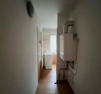 PRENÁJOM - 3-izbového byt vyhľadávaná a kľudná lokalita, Komárno - Úzka chodba v 3-izbovom byte so zariadením na stene a oknom na konci.