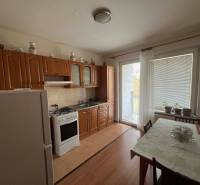 PRENÁJOM - 3-izbového byt vyhľadávaná a kľudná lokalita, Komárno - Kuchyňa v 3-izbovom byte s podlahou s dreveným dekorom a sklenenými dverami na balkón.