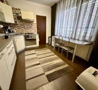 3 izbový byt  Topoľčany blízko centra - Kuchyňa v 3-izbovom byte s tmavou podlahou a veľkým oknom.