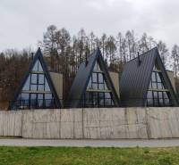 Luxusná Apartmánová chata Domaša Eva: Airbnb Hit! - Chaty na ulici Evy v Holčíkovciach s trojuholníkovou strechou obkolesené prírodou a lesom.