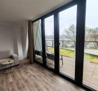 Luxusná Apartmánová chata Domaša Eva: Airbnb Hit! - Interiér chaty s pohovkou, podlaha s dreveným dekorom, veľké okná s výhľadom na terasu.