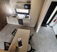 Luxusná Apartmánová chata Domaša Eva: Airbnb Hit! - Interiér chaty s jedálenským stolom, kuchynskou linkou a dreveným dekorom podlahy.