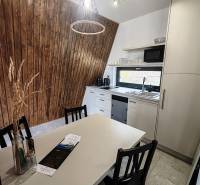 Luxusná Apartmánová chata Domaša Eva: Airbnb Hit! - Kuchyňa v Chate s podlahou s dreveným dekorom, drevenými stenami a moderným vybavením.