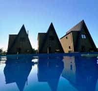 Luxusná Apartmánová chata Domaša Eva: Airbnb Hit! - Chaty na ulici Evy v Holčíkovciach pri bazéne s modrou vodnou hladinou.