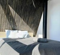 Luxusná Apartmánová chata Domaša Eva: Airbnb Hit! - Posteľ s pruhovanou prikrývkou a drevenými stenami v Chate.