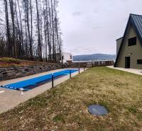 Luxusná Apartmánová chata Domaša Eva: Airbnb Hit! - Chata na ulici Evy v Holčíkovciach s bazénom a trávnikom obklopená lesom.