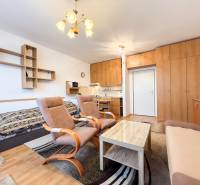 Na prenájom garsónka 30m2, Východná - Trenčín - Garsónka s podlahou s dreveným dekorom, sedačkou, kreslami a vstavanou skriňou.