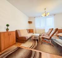 Na prenájom garsónka 30m2, Východná - Trenčín - Obývacia časť garsónky s hnedým nábytkom a podlahou s dreveným dekorom.