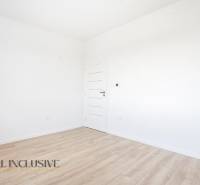 Na predaj 3-izb. byt so záhradou, Dunajská Streda - Prázdna izba s bielymi stenami a podlahou s dreveným dekorom v 3-izbovom byte.