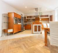 Priestranný 4-izbový byt s predzáhradkou, Staré Mesto - Kuchyňa v 4-izbovom byte s podlahou s dreveným dekorom a zabudovanými spotrebičmi.