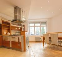 Priestranný 4-izbový byt s predzáhradkou, Staré Mesto - Kuchyňa s jedálenským kútom v 4-izbovom byte, podlaha s dreveným dekorom, biela stena.