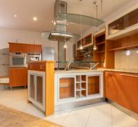 Priestranný 4-izbový byt s predzáhradkou, Staré Mesto - Kuchyňa v 4-izbovom byte s ostrovčekom a podlahou s dreveným dekorom.