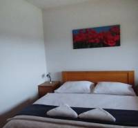 Predaj !Elegantný byt s wellness prvkami pri Jasnej - Spálňa s manželskou posteľou a drevenými nočnými stolíkmi v 2-izbovom byte.