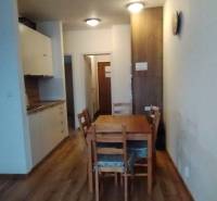 Predaj !Elegantný byt s wellness prvkami pri Jasnej - Jedáleň v 2-izbovom byte s podlahou s dreveným dekorom a dreveným stolom.