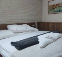 Predaj !Elegantný byt s wellness prvkami pri Jasnej - Spálňa s dreveným nábytkom a obrazom, podlaha s dreveným dekorom, 2-izbový byt.