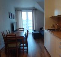 Predaj !Elegantný byt s wellness prvkami pri Jasnej - Kuchynský kút s jedálenským stolom a podlahou s dreveným dekorom v 2-izbovom byte.