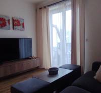 Predaj !Elegantný byt s wellness prvkami pri Jasnej - Obývacia izba s televízorom, podlahou s dreveným dekorom a pohodlným gaučom v 2-izbovom byte.