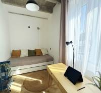 - PRENÁJOM - 3 IZBOVÝ BYT - WILSONOVA UL. - STARÉ MESTO - Izba v 3-izbovom byte s dreveným dekorom, posteľou a písacím stolom s tabletom.