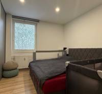 KOMPLETNE prerobený 4i byt s balkónom, 77m2 - ZÁTVOR - Spálňa v 4-izbovom byte s posteľou, skriňou a dreveným dekorom podlahy.