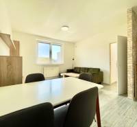 Na prenájom slnečný 2i byt s balkónom, ul. Východná, Trenčín - Obývacia izba v 2-izbovom byte s podlahou s dreveným dekorom, sedačka a jedálenský stôl.